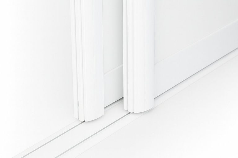Zwei weiße Türleisten an einem schlichten weißen Wand- und Bodenbereich.